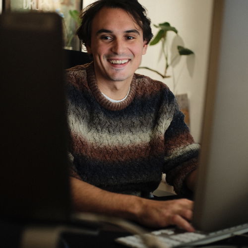 Happy producer sitting at a computer working